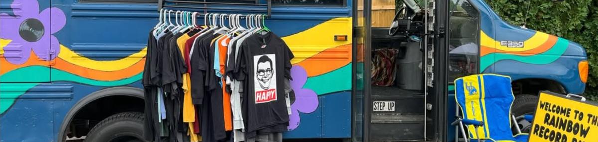 Rainbow Record Bus on location with band shirts and signage Rainbow Record Bus on location